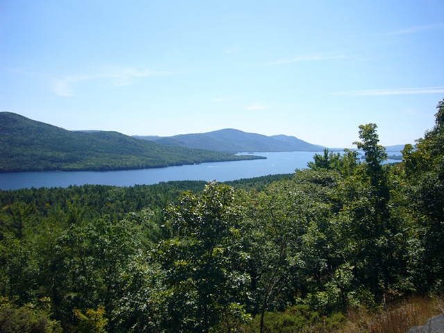 View atop Wing Pond showing a calm Lake George with mountains in the distance.
