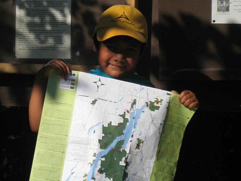 A child holds up a map of Lake George.