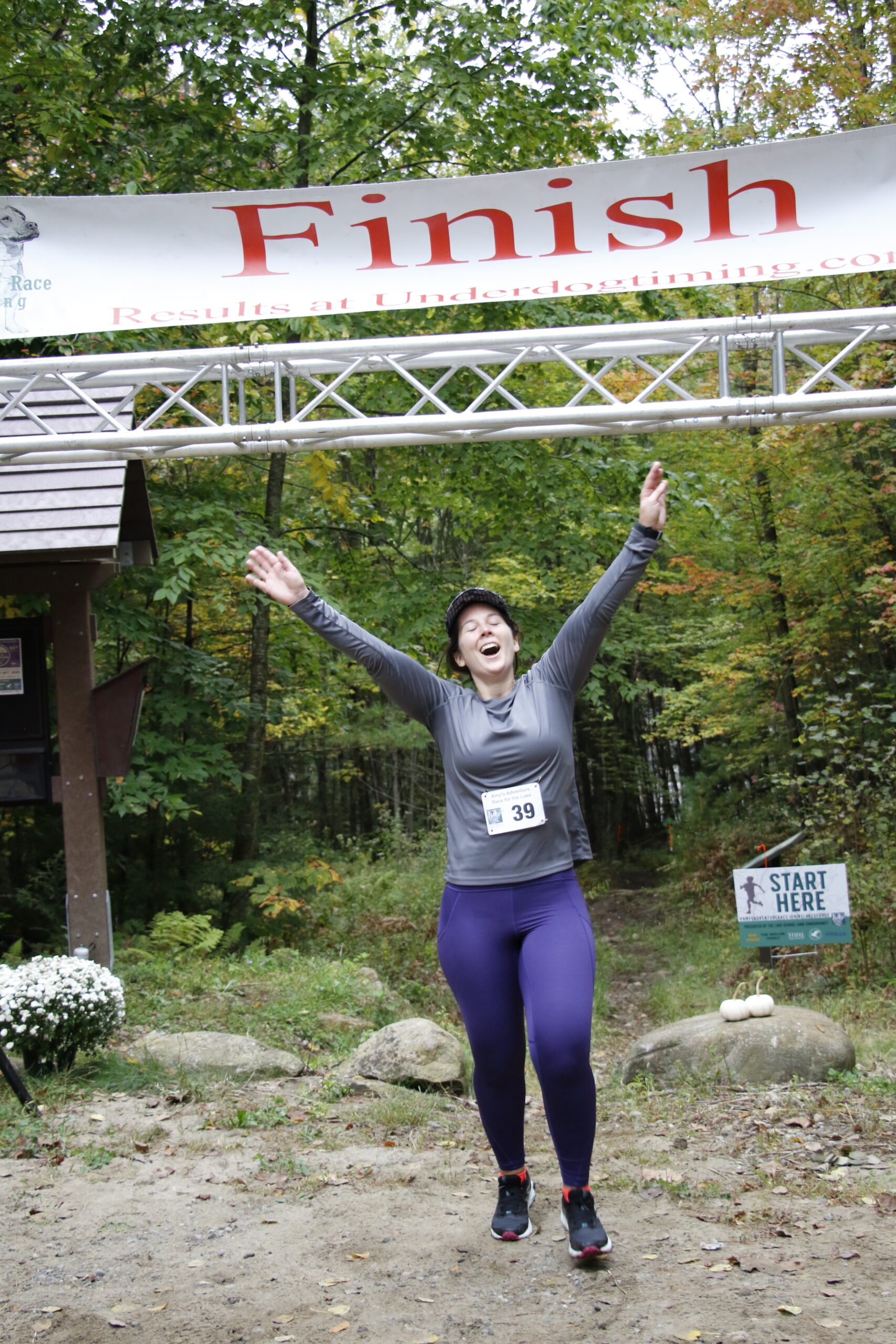 A woman cheers as she crosses the finish line.